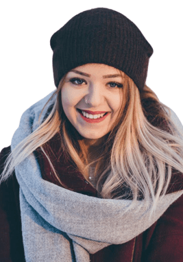 A woman wearing a hat and scarf smiling for the camera.