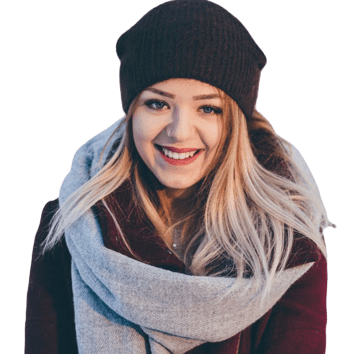 A woman wearing a hat and scarf smiling for the camera.